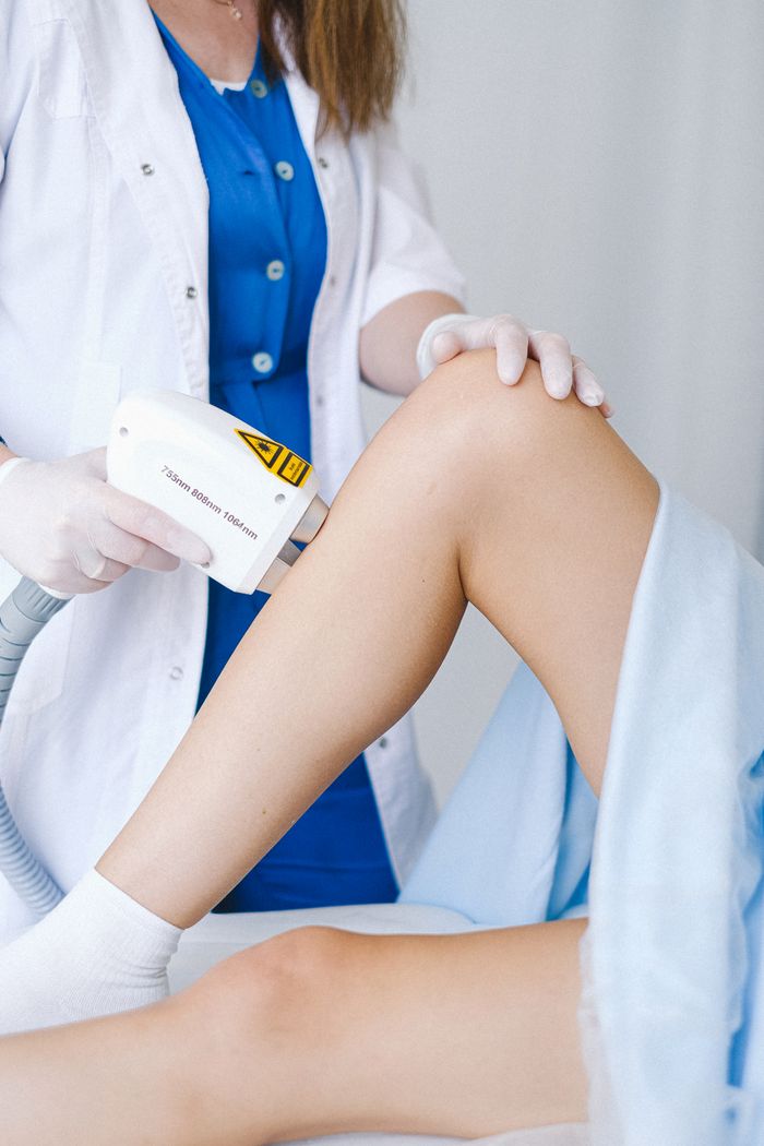 services-04 Crop unrecognizable doctor in medical uniform and gloves using professional equipment for low level laser therapy for client